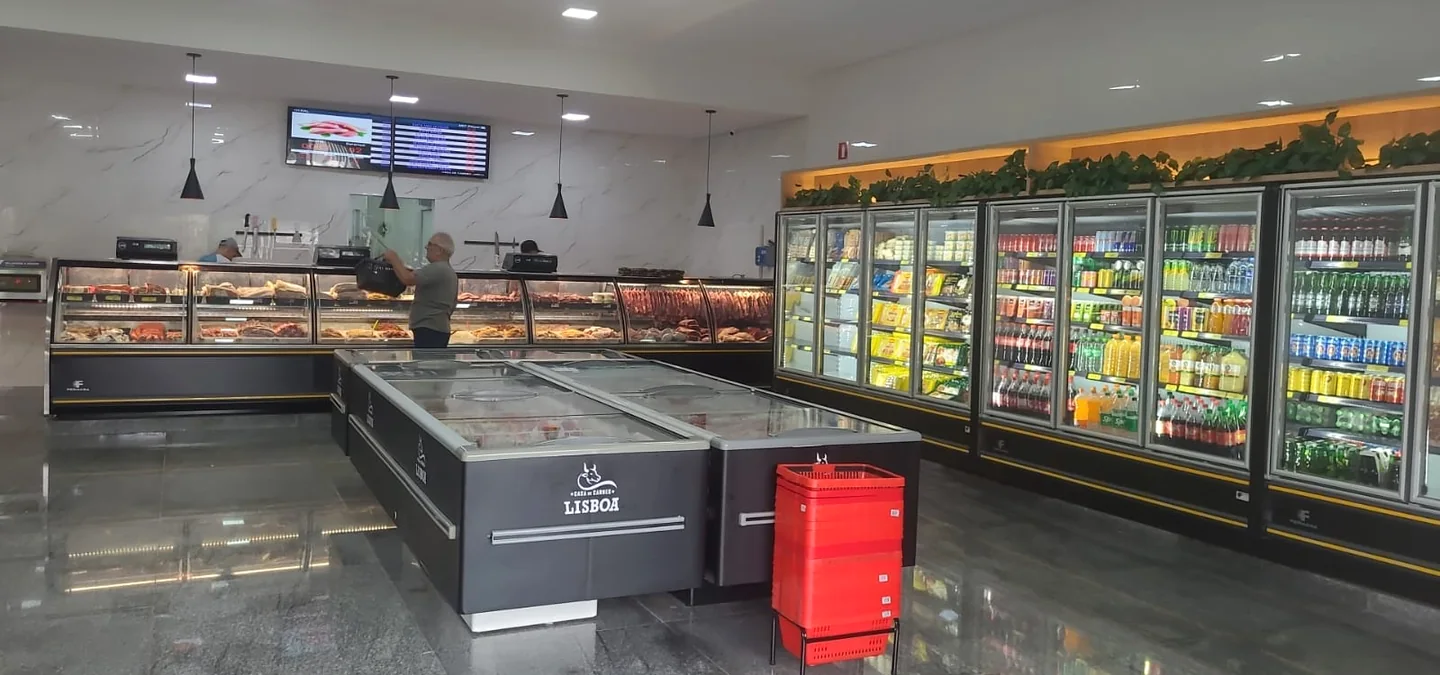 Interior da Casa de Carnes Lisboa, com balcão de carnes e refrigeradores.